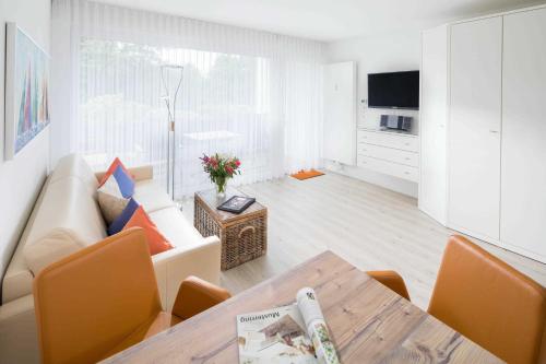 sala de estar con sofá y mesa en Südpark, en Norderney