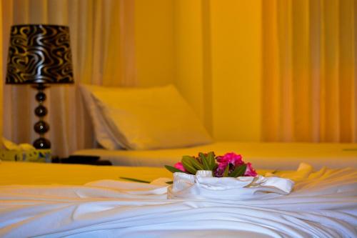a bouquet of pink flowers on a bed at Beach Palace in Hulhumale