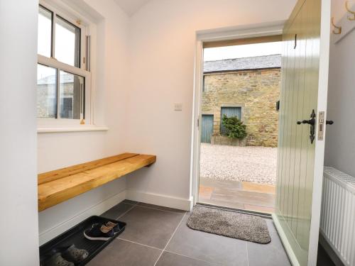 a pivot door in a room with a window at 1 Hull House Cottage in Skipton