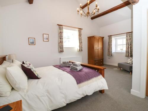 una camera con letto, sedia e finestre di 3 Hull House Cottage a Skipton