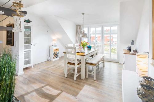 a kitchen and dining room with a table and chairs at Strandperle Ney in Norderney