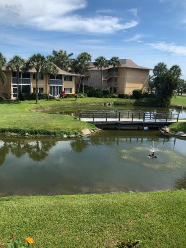 a bridge over a pond in front of condos at Beach bungalow at Ocean Village in Fort Pierce