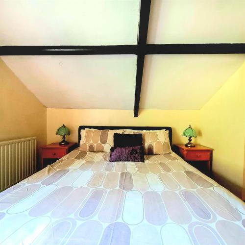 a bedroom with a large bed with two night stands at Ta Mill Cottages & Lodges - Pump Cottage in Launceston