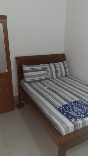 - un lit avec des draps et des oreillers bleus et blancs dans l'établissement Aziz Gaff, à Dakar