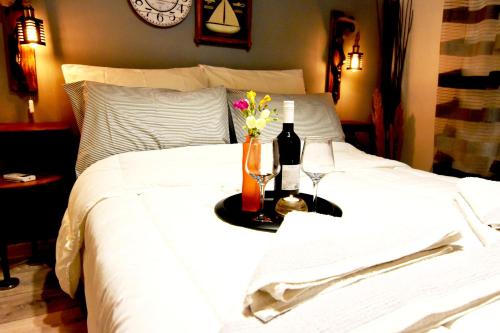 a bed with a bottle of wine and flowers on it at Casa Katina , villa in Lagana, Agrilia area in Laganas