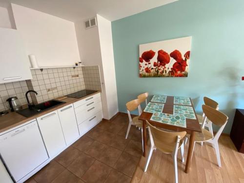 a kitchen with a table and chairs in a room at Apartamenty Maki Marea in Międzyzdroje