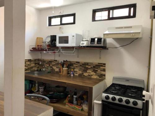 a kitchen with a stove and a microwave at Casa Nova! PRIVATE BATHROOM AND ROOM in Cancún