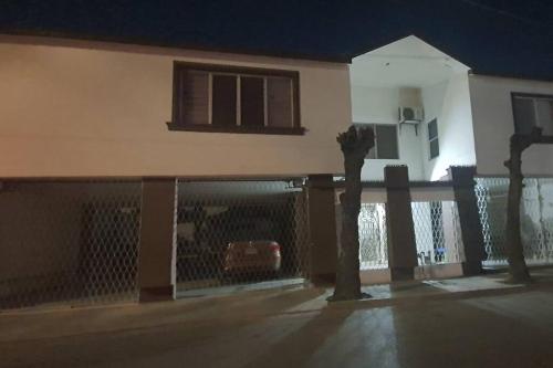 a fence in front of a house with a car at DEPARTAMENTO NUEVO Y CENTRICO EN MITRAS NORTE in Monterrey
