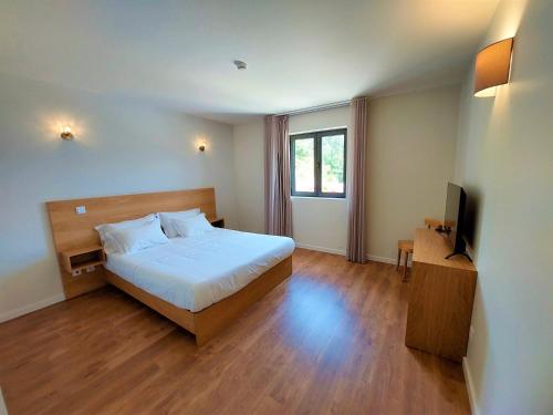 a bedroom with a bed and a television in it at Quinta da Roda Hotel - Conforto e Tranquilidade no Gerês in Cela