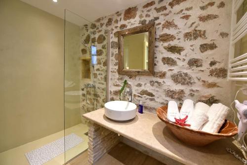 a bathroom with a sink and a glass shower at Sterna Apartment in Hydra