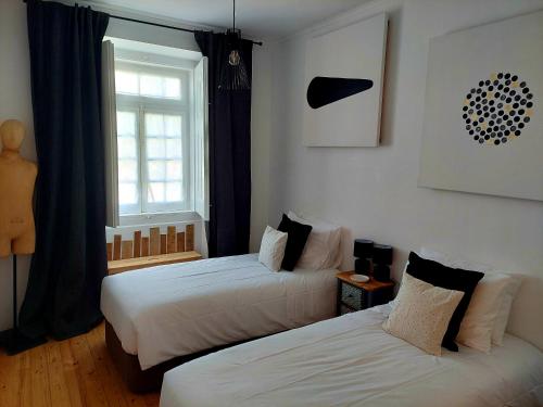 a room with two beds and a window at Casa da Livraria - Boutique da Cultura in Avis