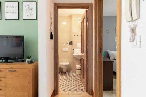 een badkamer met een toilet en een televisie in een kamer bij SeaEsta apartment Pool and Beach in Slatine