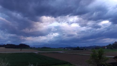 a cloudy sky with a field and a road at Pension Persch in Völkermarkt