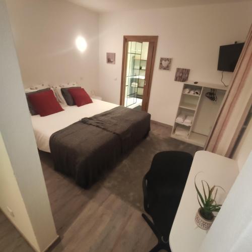 a bedroom with a bed and a table and a chair at Family House in Vila do Bispo
