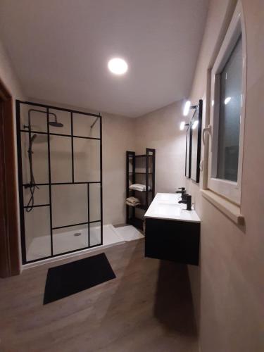 a bathroom with a white sink and a window at Family House in Vila do Bispo
