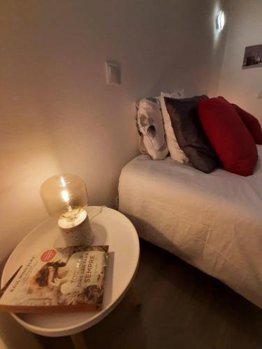 a small room with a bed and a table with a book at Family House in Vila do Bispo