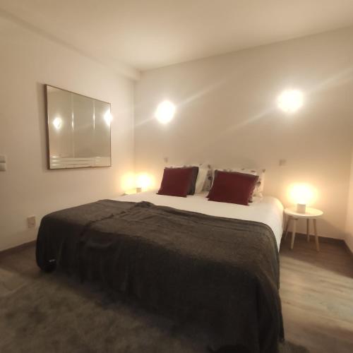 a bedroom with a large bed with two lamps at Family House in Vila do Bispo