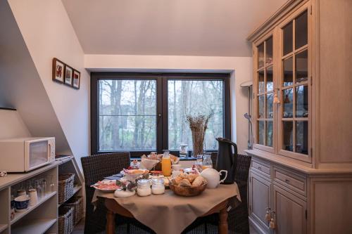 a kitchen with a table with food on it at B&B De Klaproos in Merkem