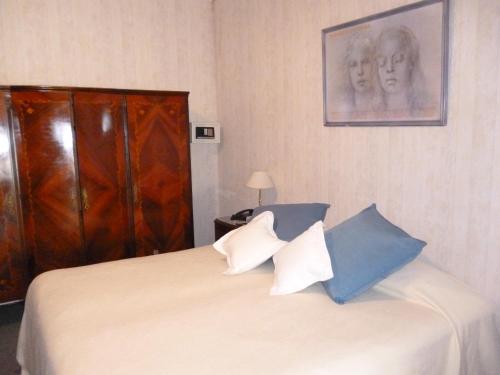 um quarto com uma cama com almofadas azuis e brancas em Hosteria Pastoral & Spa em La Cumbre