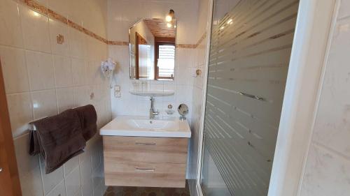 a small bathroom with a sink and a shower at Hotel Pension Wolf in Ebermannstadt