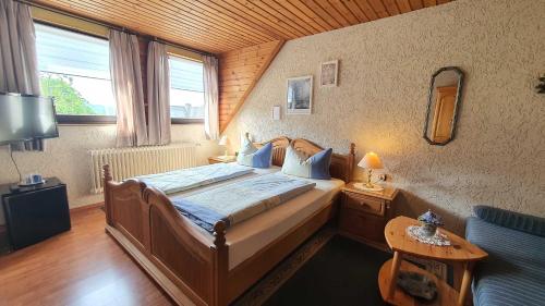 a bedroom with a large bed with a wooden ceiling at Hotel Pension Wolf in Ebermannstadt