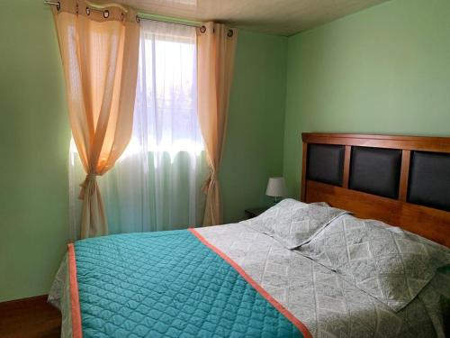 a bedroom with a bed and a window with curtains at Hospedaje La ruta Los Angeles in Los Ángeles