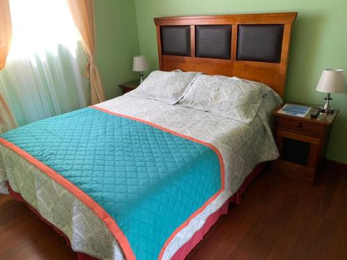 a bedroom with a large bed with a wooden headboard at Hospedaje La ruta Los Angeles in Los Ángeles