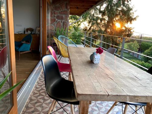 a wooden table and chairs on a balcony at Hello Balaton in Alsóörs