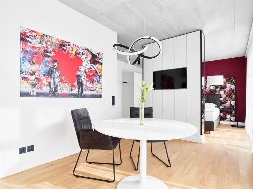 uma sala de jantar branca com uma mesa e cadeiras brancas em livisit bergapartments em Stuttgart