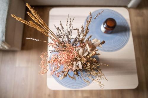 un plato azul con un ramo de flores secas en LITTLE BAHIA en Saint-Malo