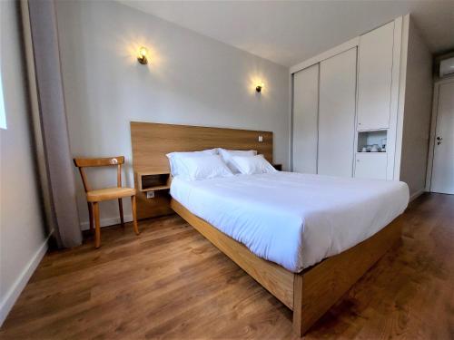 a bedroom with a large bed and a chair at Quinta da Roda Hotel - Conforto e Tranquilidade no Gerês in Cela