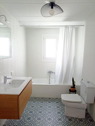 a bathroom with a tub and a toilet and a sink at Cal Pigat in Miravet