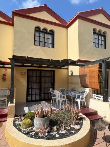a patio with a table and chairs in front of a house at Casa Ucraniana Wi-Fi fibra in Costa Calma
