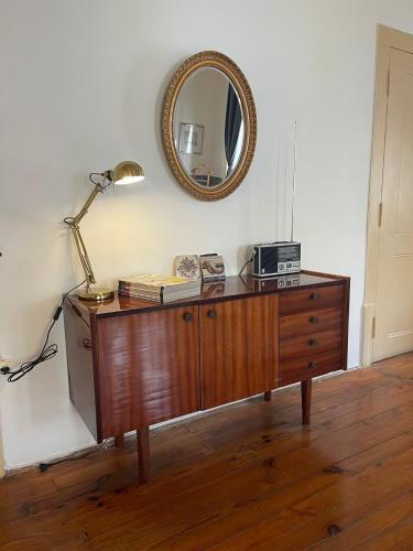 a dresser with a lamp and a mirror on a wall at Azulejos Cais Sodré B&B in Lisbon
