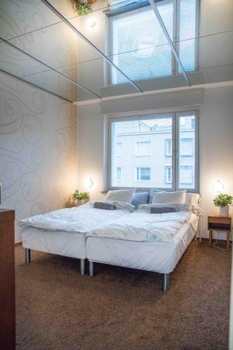 a bedroom with a large bed with a large window at Iso perheasunto keskustassa, Särkänniemen lähellä in Tampere