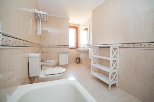 a bathroom with a toilet and a sink and a tub at Apartamentos Ría de Bayona in Baiona