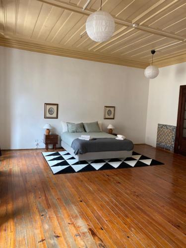 a bedroom with a bed on a wooden floor at Azulejos Cais Sodré B&B in Lisbon