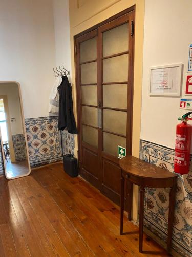 um quarto com uma porta de madeira e uma mesa em Azulejos Cais Sodré B&B em Lisboa