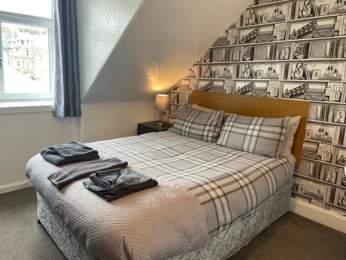 a bedroom with a bed and a wall with pictures at Dunarle Guesthouse in Oban