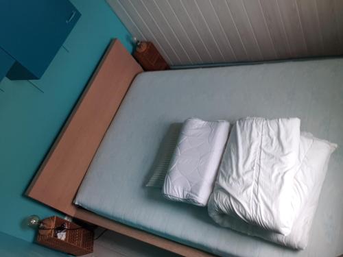 - un lit avec 2 oreillers blancs dans l'établissement Cap d'Agde , Location Saisonnière 2 4 6 personnes , 1 Chambre , Cap d'Agde, au Cap d'Agde