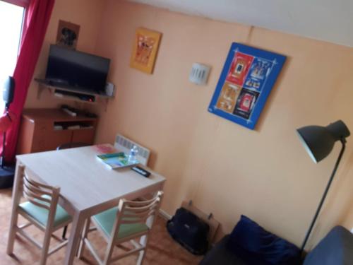 un salon avec une table et une télévision dans l'établissement Cap d'Agde , Location Saisonnière 2 4 6 personnes , 1 Chambre , Cap d'Agde, au Cap d'Agde