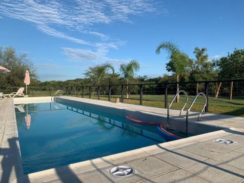 una piscina con una valla metálica y árboles en El Descanso en Colón