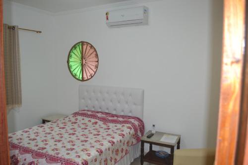 een slaapkamer met een bed en een klok aan de muur bij Casa Adonai in Miguel Pereira