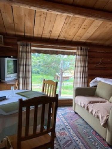 a living room with a couch and a table and a window at Nimpo Lake Resort in Nimpo Lake