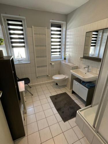 a bathroom with a toilet and a sink and a tub at Ferienwohnung am Yachthafen Waren Müritz in Waren