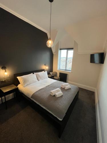 1 dormitorio con 1 cama con 2 toallas en Ormes Hey Apartments, en Llandudno