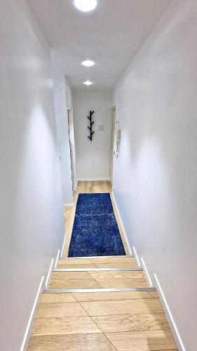 - un couloir avec un tapis bleu au sol dans l'établissement Loft de luxe Tour Eiffel, à Paris