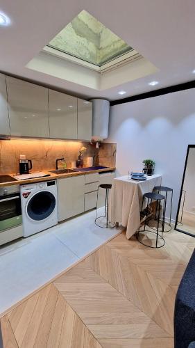 La cuisine est équipée d'une table, d'un évier et d'un lave-vaisselle. dans l'établissement Loft de luxe Tour Eiffel, à Paris