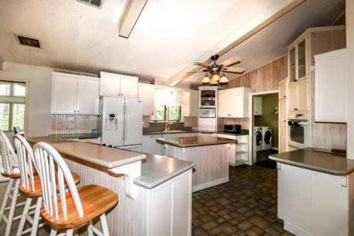 a large kitchen with white cabinets and white appliances at 05244 - 44 Pego Circle in Hot Springs Village
