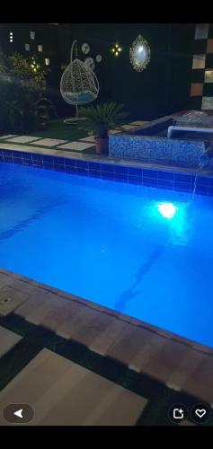 a swimming pool with blue lights on it at استراحة توسكانا Toscana Villa in Obhor